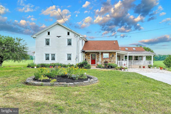 A white house sitting on top of a lush green field